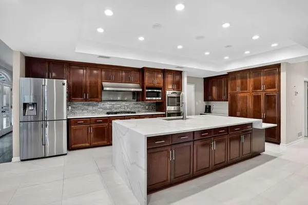 a kitchen with stainless steel appliances granite countertop a stove a refrigerator and a sink
