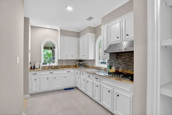 a kitchen with granite countertop white cabinets and white appliances