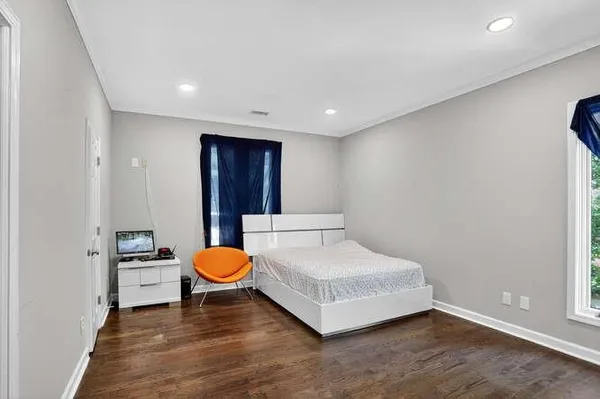 a spacious bedroom with a bed and painting on the wall