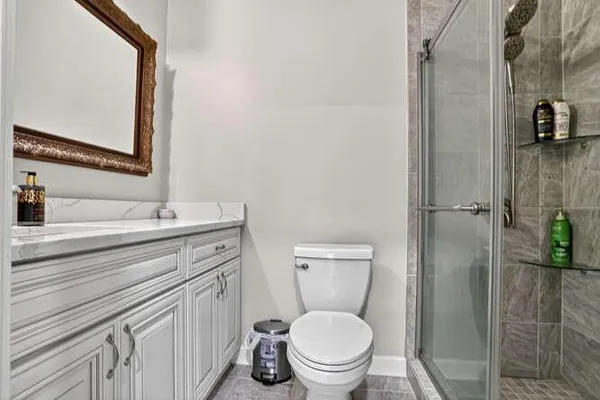 a bathroom with a toilet sink vanity and granite