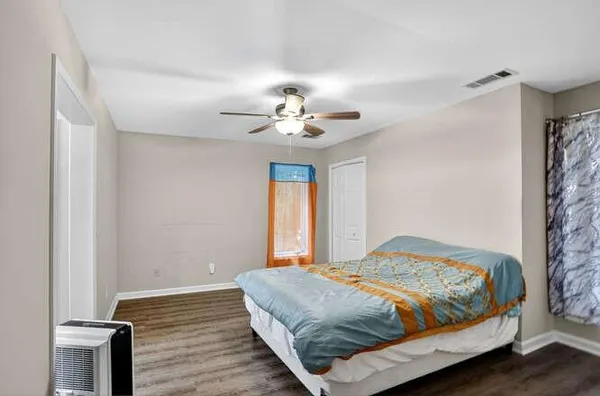 a bedroom with a bed and a ceiling fan