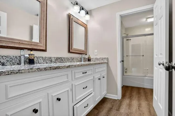 a bathroom with a granite countertop sink and a mirror