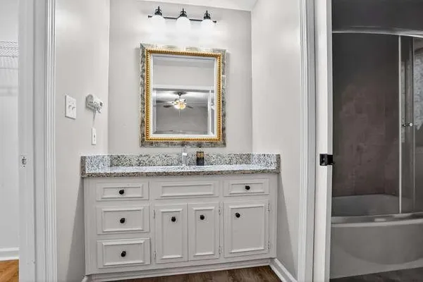 a bathroom with a granite countertop sink a toilet and bathtub