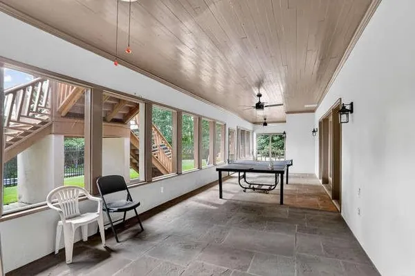 a living room with furniture a flat screen tv and a large window