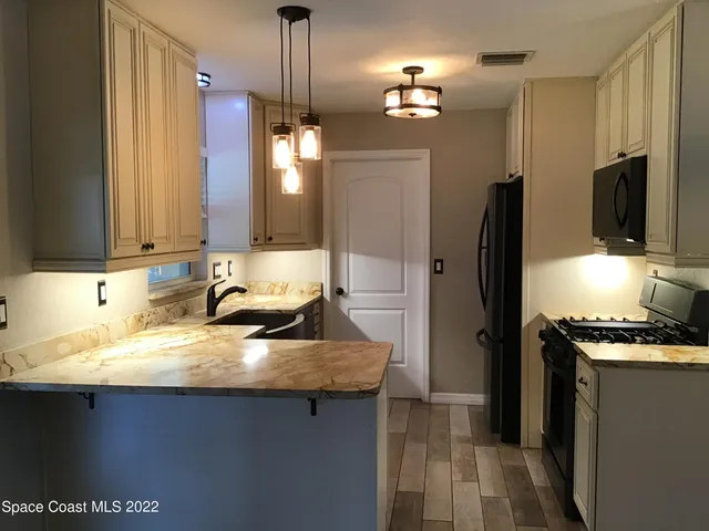 a kitchen with stainless steel appliances a sink stove and refrigerator