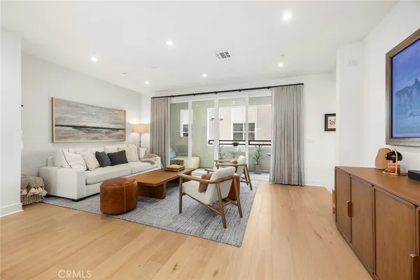 a living room with furniture wooden floor and a large window