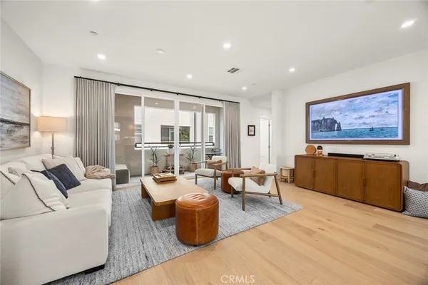 a living room with furniture wooden floor and a large window