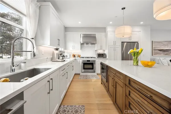 a large white kitchen with a stove and a sink