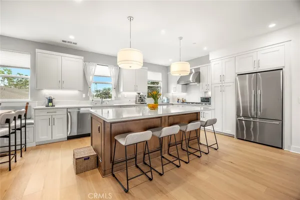 a kitchen with a dining table chairs sink refrigerator and cabinets