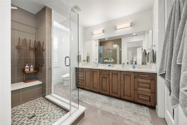 a bathroom with a double vanity sink a large mirror and a shower