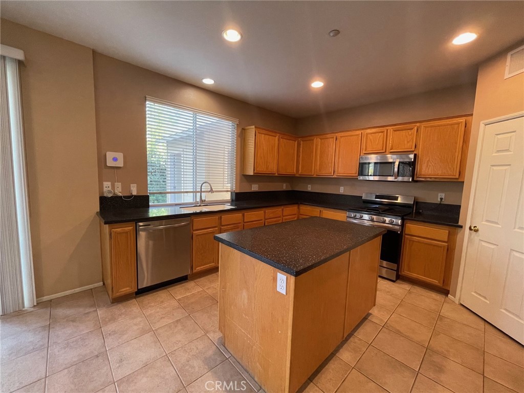 1434 Haddington Drive Riverside, CA 92507 - Photo 12 of 40 a kitchen with stainless steel appliances granite countertop a stove a sink and a refrigerator