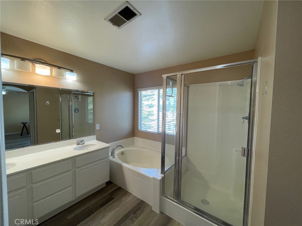1434 Haddington Drive Riverside, CA 92507 - Photo 29 of 40 a bathroom with a bathtub and a double vanity sink mirror