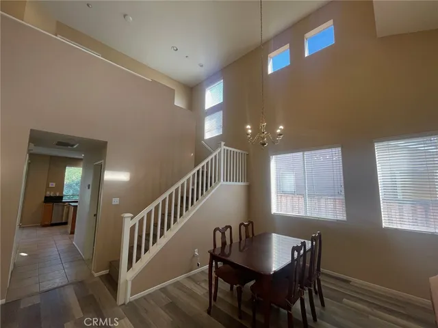 a view of a a dining room with furniture window and wooden floor