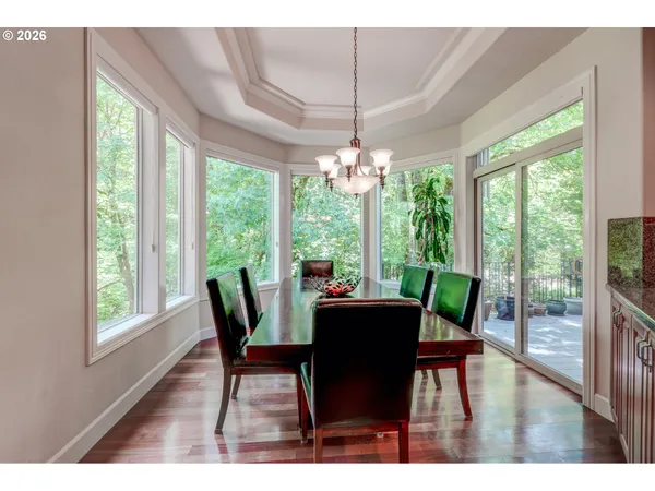 a dining room with furniture large windows and wooden floor