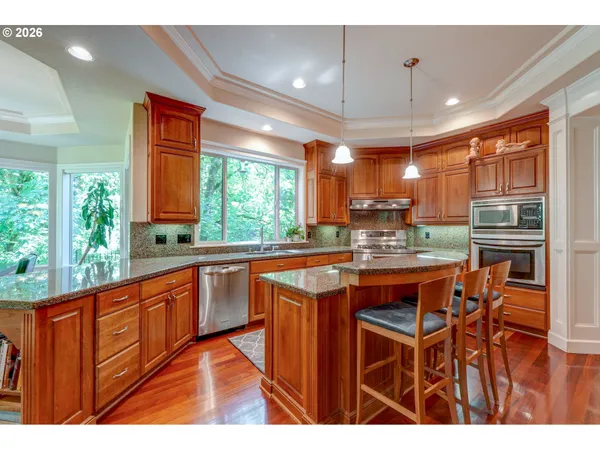 a kitchen with stainless steel appliances granite countertop a sink and wooden cabinets