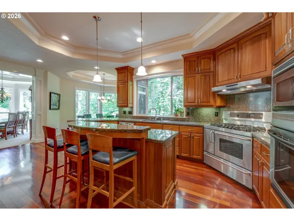 a kitchen with stainless steel appliances granite countertop a stove a sink dishwasher and a microwave