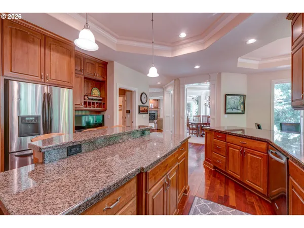 a large kitchen with kitchen island a sink stainless steel appliances wooden floor and counter space