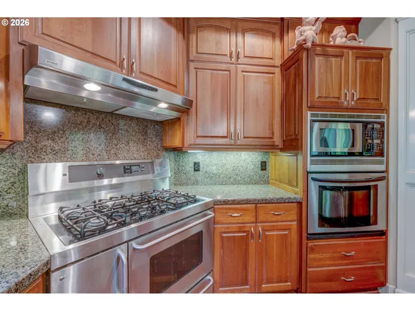 a kitchen with stainless steel appliances granite countertop a stove and a microwave