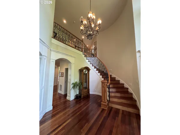 a view of a hallway with wooden floor and staircase