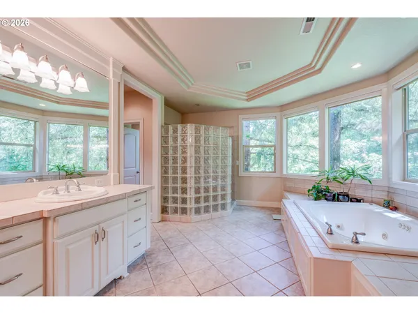 a bathroom with a sink a large mirror and a bathtub next to a window