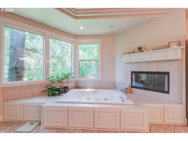 a bathroom with a tub a sink and a large window