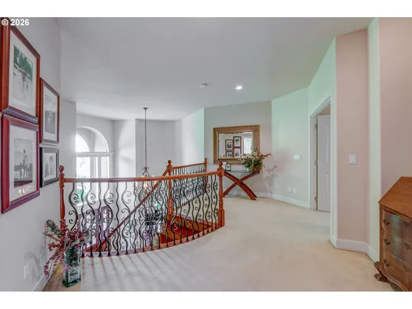 a view of a hallway with wooden floor and stairs