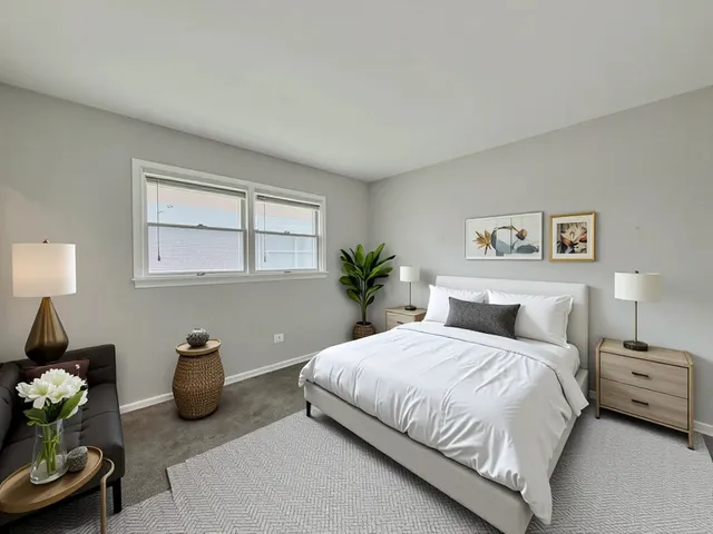a bedroom with a bed a couch and potted plant