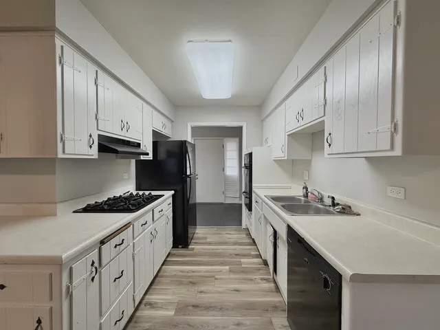 a kitchen with stainless steel appliances a sink stove and cabinets