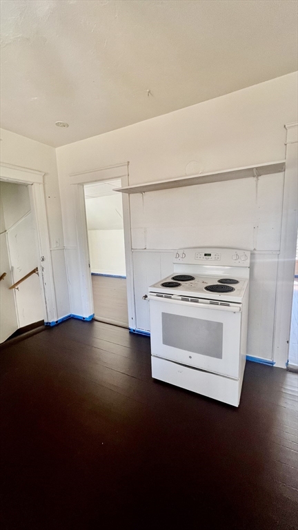 23 Firglade Street, Unit 3 Worcester, MA 01602 - Photo 4 of 12 a kitchen with a stove and white cabinets with wooden floor