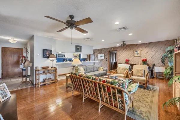 a living room with lots of furniture and a dining table with wooden floor
