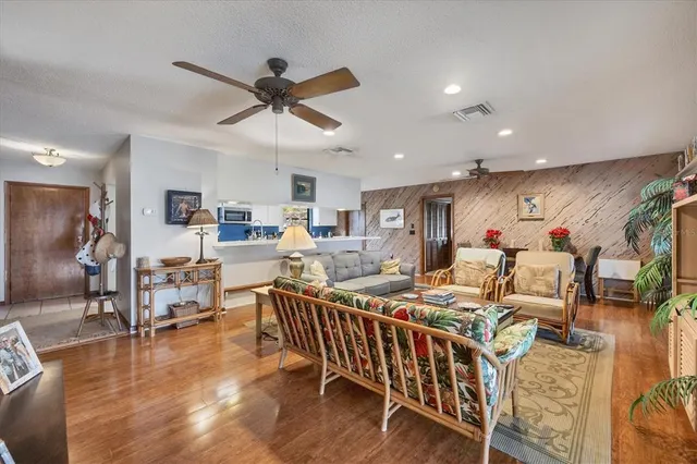 a living room with lots of furniture and a dining table with wooden floor