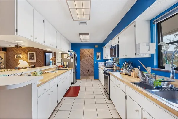 a large kitchen with stainless steel appliances granite countertop a stove a sink dishwasher and cabinets with wooden floor