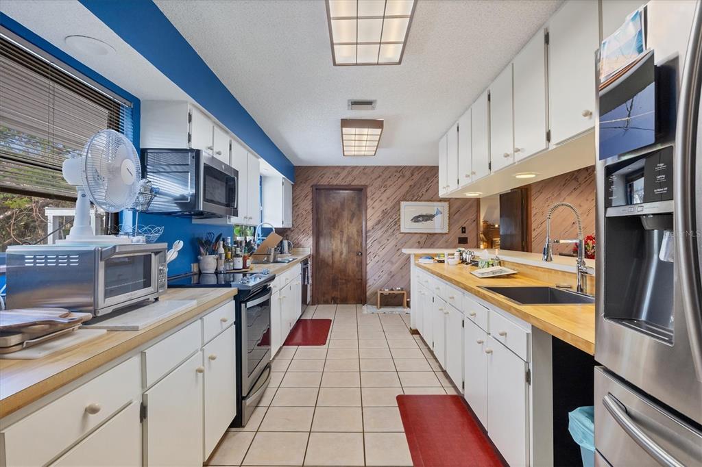140 Damfino Street Boca Grande, FL 33921 - Photo 17 of 48 a large kitchen with stainless steel appliances granite countertop a stove and a sink