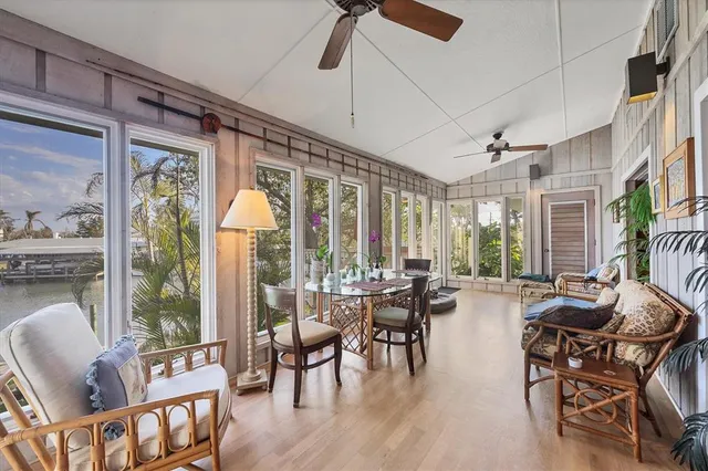 a living room with furniture a flat screen tv and floor to ceiling windows