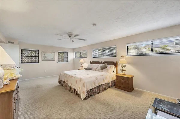 a spacious bedroom with a bed and a lamp