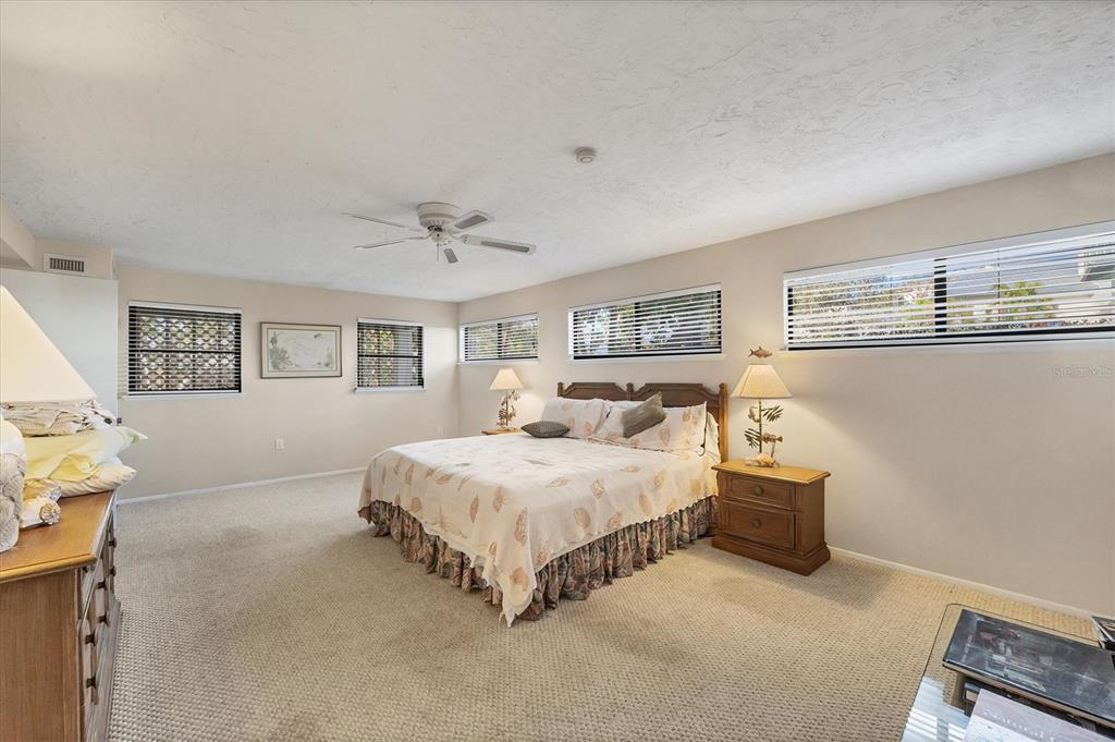 140 Damfino Street Boca Grande, FL 33921 - Photo 30 of 48 a spacious bedroom with a bed and a lamp