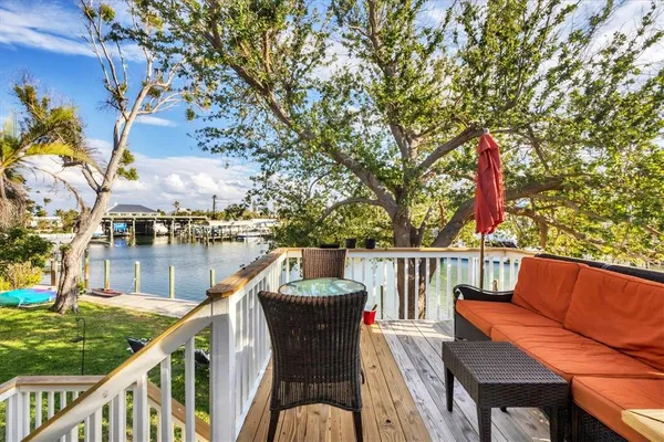 a balcony with wooden floor and outdoor seating