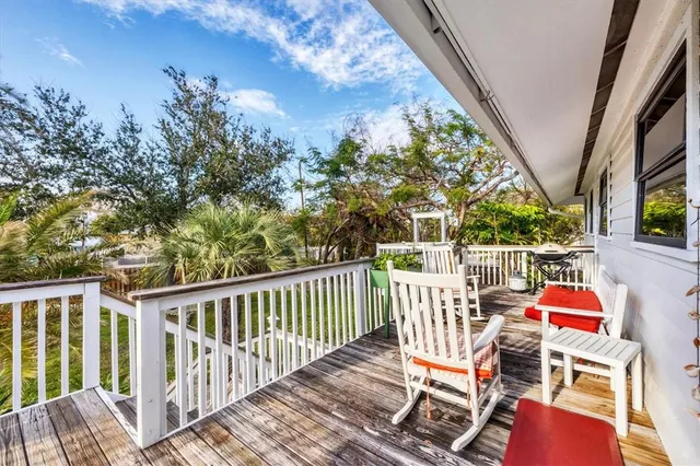 a view of deck with furniture and trees in the background