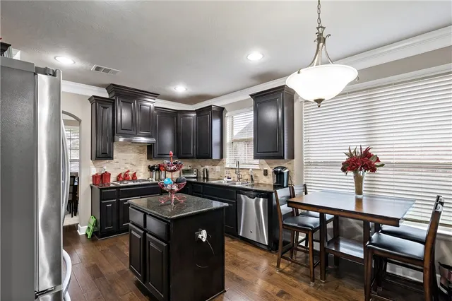 a kitchen with refrigerator a sink and chairs