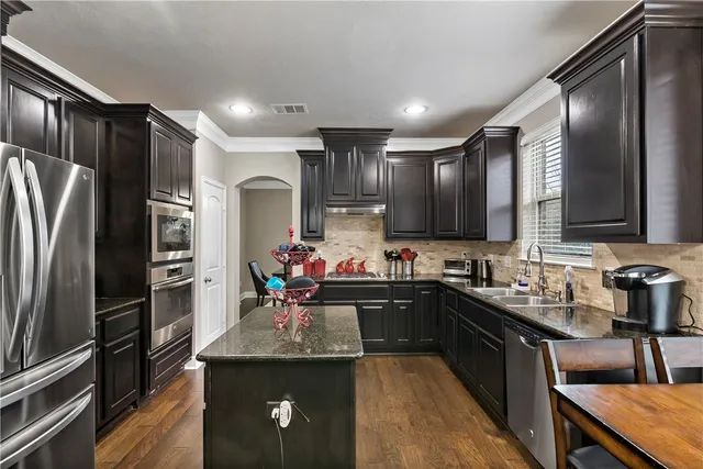 a kitchen with stainless steel appliances granite countertop a sink stove and cabinets