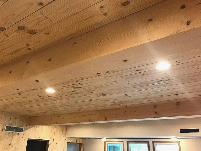 a living room with furniture a flat screen tv and kitchen view