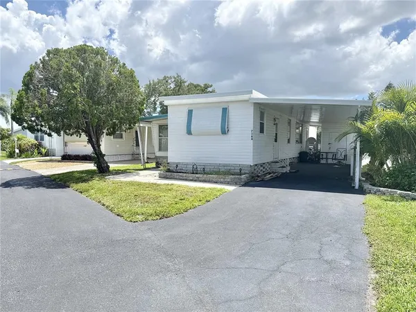 a view of a house with backyard and trees