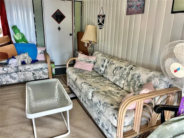 a living room with furniture and a painting on the wall
