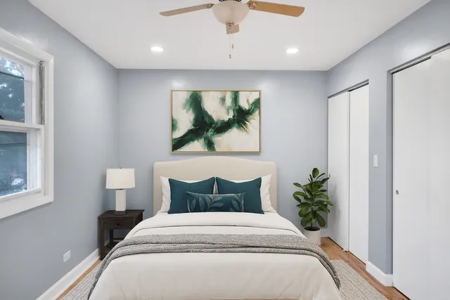 a bedroom with a bed and a painting on the wall