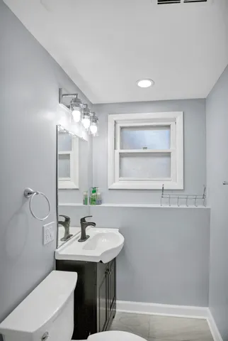 a bathroom with a sink a toilet and mirror