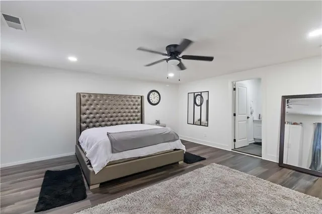 a bedroom with a large bed chandelier and a window