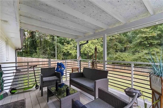 a view of a patio with couches chairs dining table and chairs with wooden floor
