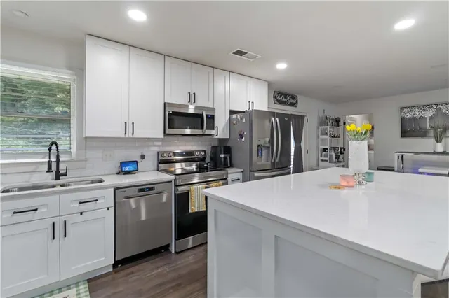 a kitchen with stainless steel appliances a stove refrigerator sink and cabinets