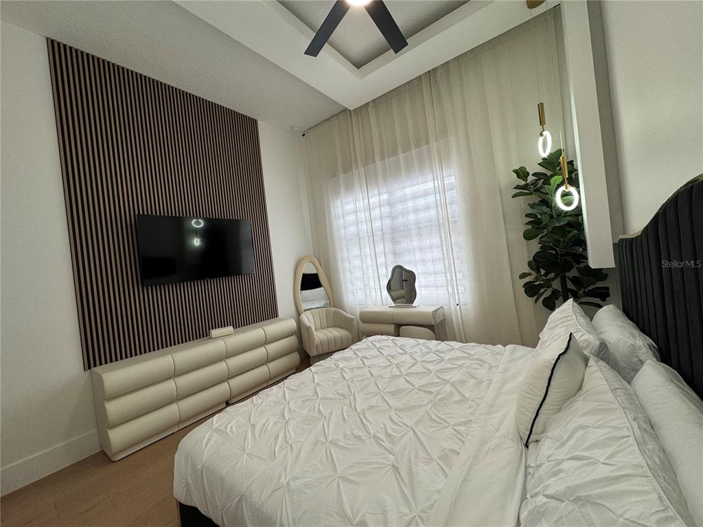 17314 Highway 41 Spring Hill, FL 34610 - Photo 31 of 54 a bedroom with a bed a flat screen tv and a potted plant