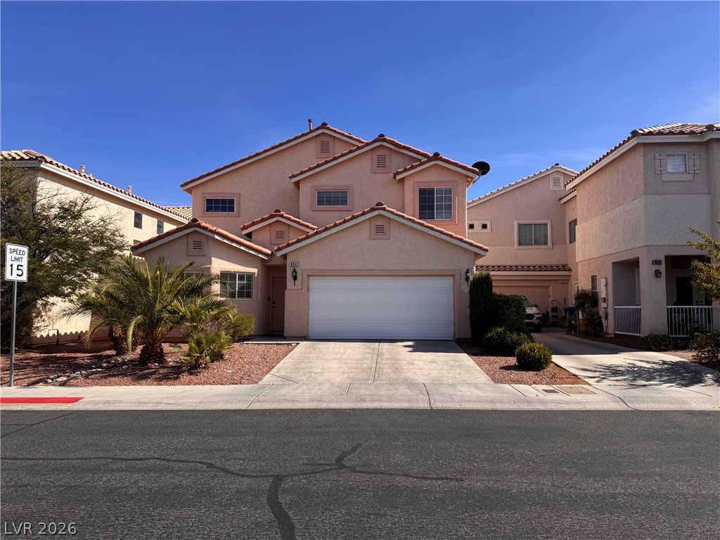 8937 Austin Ridge Avenue Las Vegas, NV 89178 - Photo 1 of 22 A terracotta-roofed residence presents a concrete driveway leading to an attached garage.